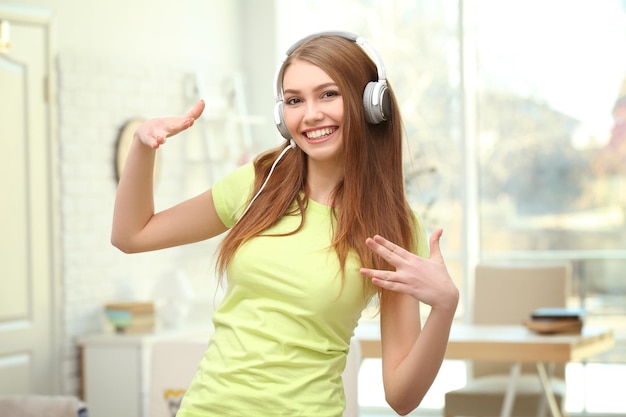 Beautiful young woman listening to music at home