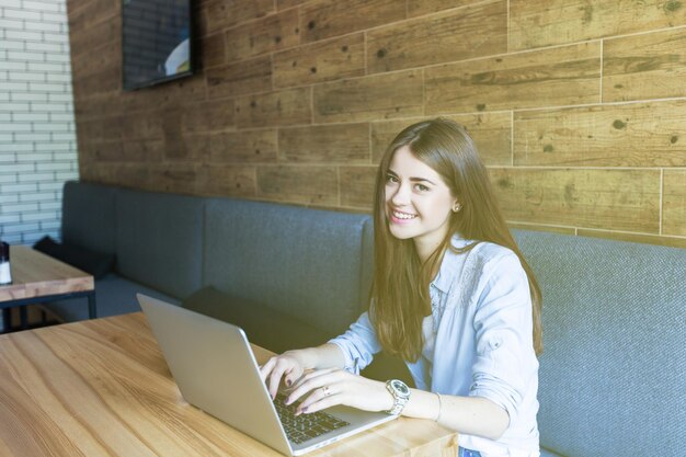 Beautiful young woman looking at the laptop