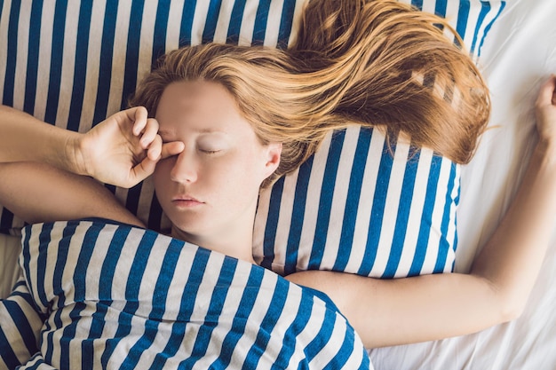 Photo beautiful young woman lying down in bed and sleeping. do not get enough sleep concept.