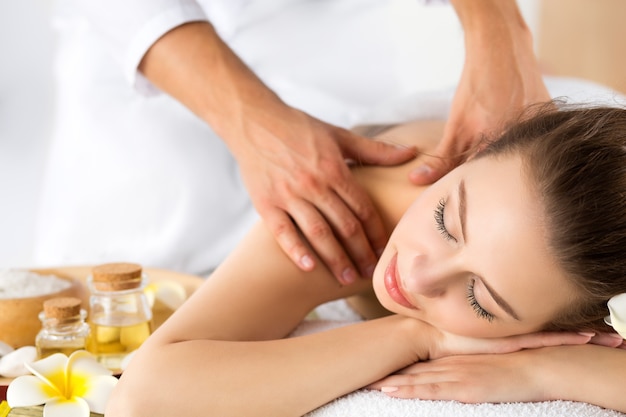 Beautiful young woman lying down at spa salon