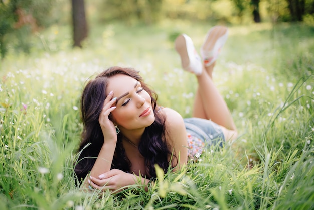 Beautiful young woman lying on the grass