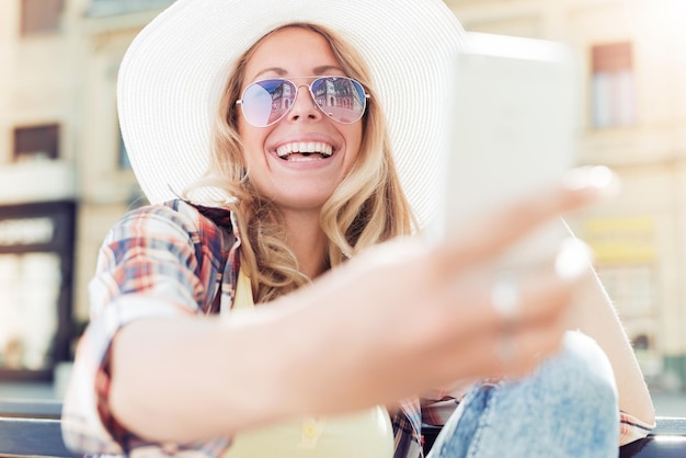 Beautiful young woman making selfie photo with smart phone.