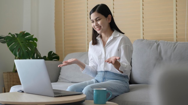 A beautiful young woman making video conference call via computer at home