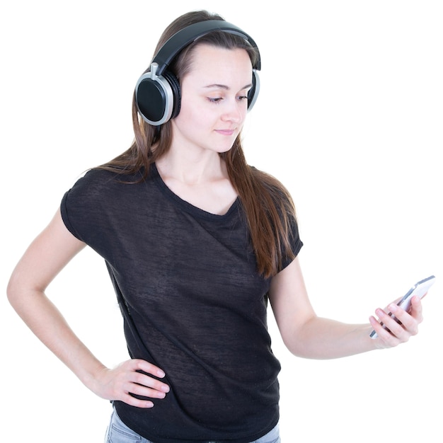 Красивая молодая женщина модель лица на мобильном телефоне, глядя вверх, слушая музыку в наушниках, стоя на белом фоне