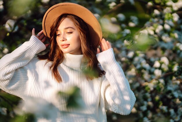 Beautiful young woman near blooming spring tree Youth love romantic concept