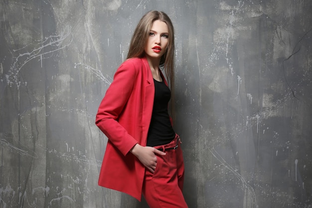 Beautiful young woman near grunge wall