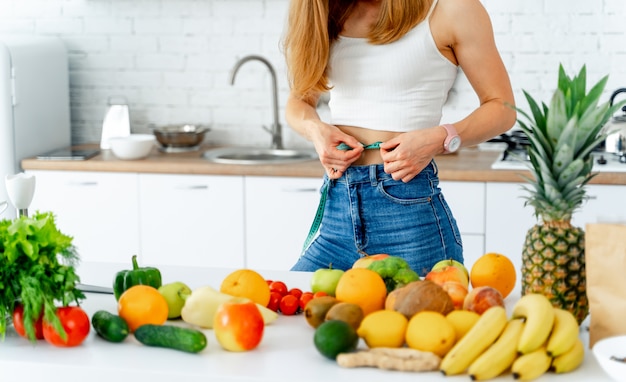 Beautiful Young Woman near in the kitchen with healthy food.