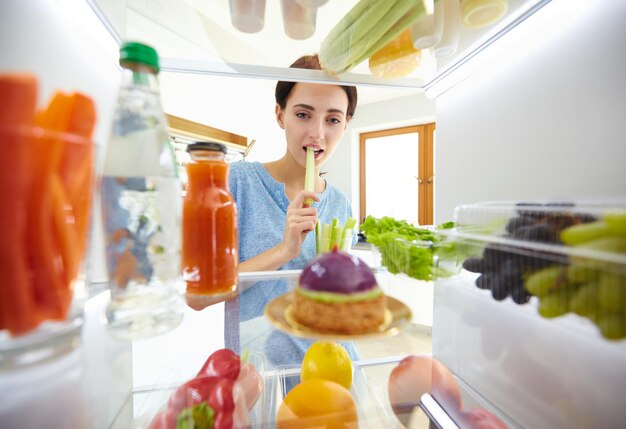 Beautiful Young woman near the refrigerator with healthy food