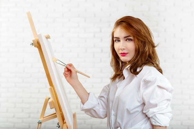 Beautiful young woman painter at work