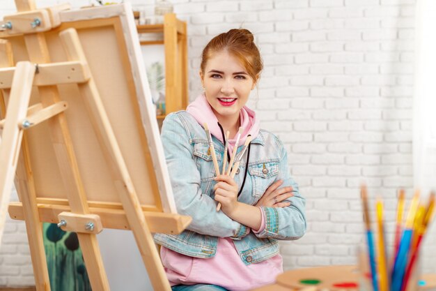 Beautiful young woman painter at work