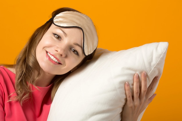 Photo beautiful young woman in a pink dress with a pillow