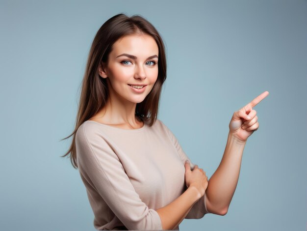 Beautiful young woman pointing up to copy space and looking at camera