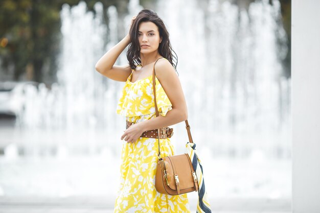 Beautiful young woman portrait. Female outdoors on summertime. Beauty near the fountain. Urban stylish lady.