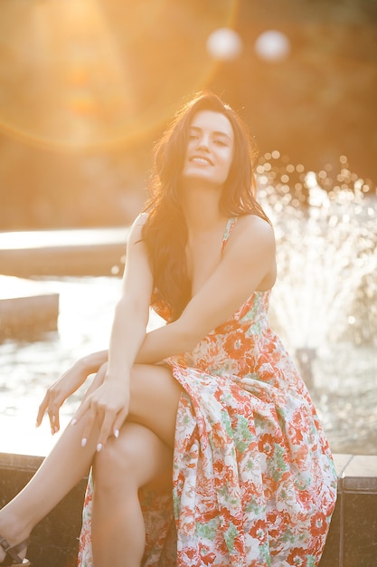 Beautiful young woman portrait. Female outdoors on summertime. Beauty near the fountain. Urban stylish lady.