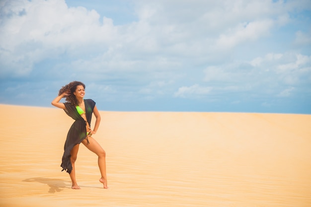 Beautiful young woman posing in the desert sand