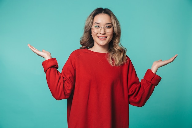 a beautiful young woman posing isolated over blue wall wall