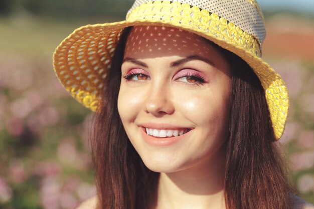 Beautiful young woman posing near roses in a garden.