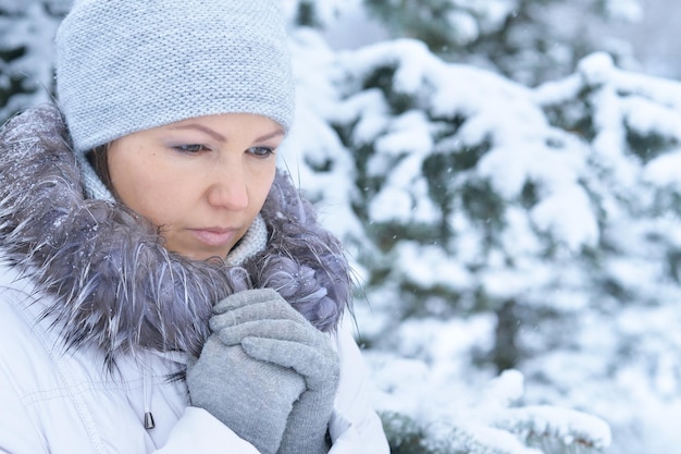 Beautiful young woman posing outdoors in winter