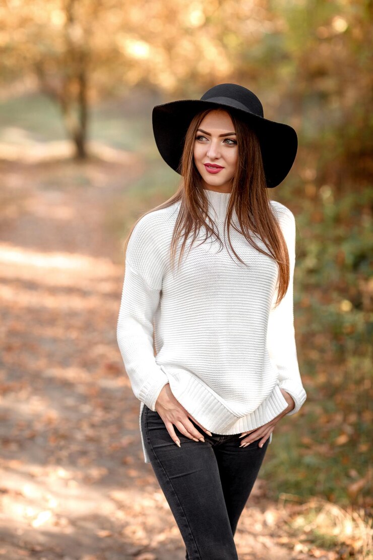 Beautiful young woman posing in park in the autumn