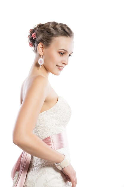 The beautiful young woman posing in a wedding dress. Beauty make-up. Jewellery