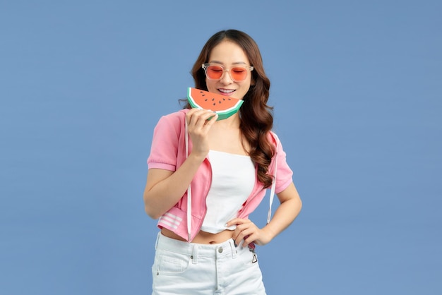 Beautiful young woman posing with watermelon on color background