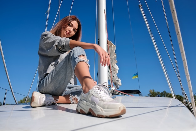 Beautiful young woman posing on yacht.