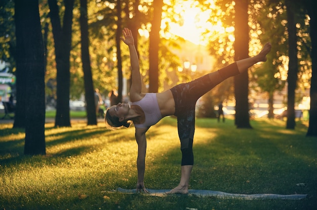 아름 다운 젊은 여자 관행 요가 아사 나 Ardha Chandrasana