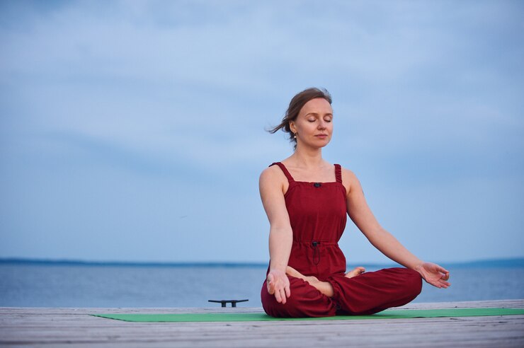 Beautiful young woman practices yoga asana Padmasana