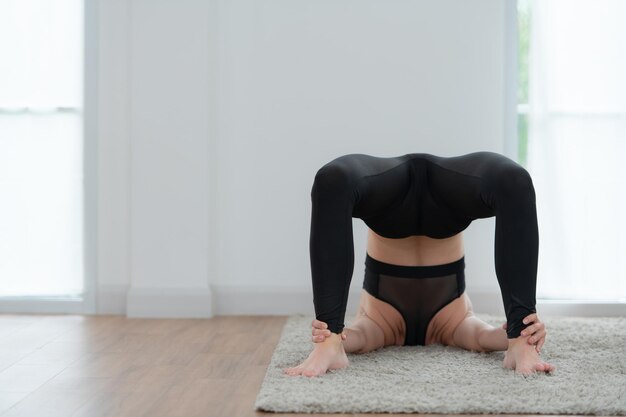 Beautiful young woman practicing yoga at home Yoga asana