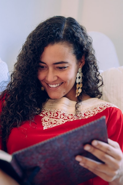 Photo beautiful young woman reading a book at home