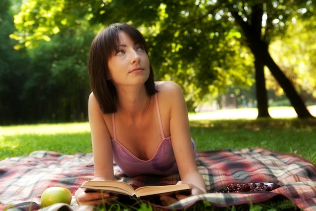 Beautiful young woman reading outdoor