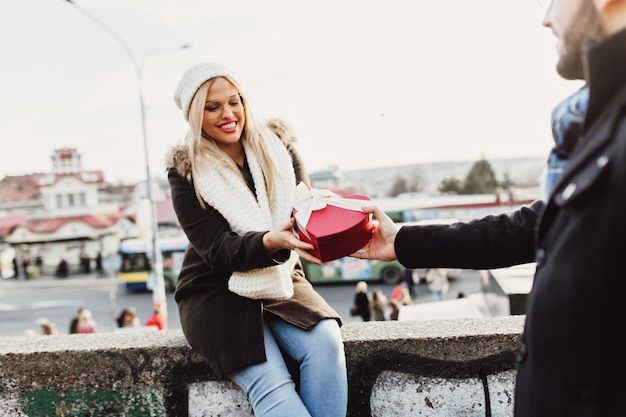 Beautiful young woman receiving gift from her boyfriend.