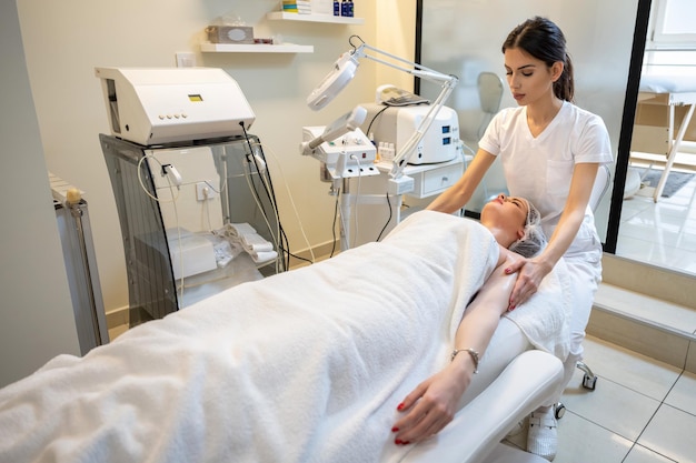 beautiful young woman receiving massage in spa salon