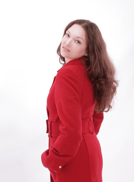 Beautiful young woman in a red coat isolated on white