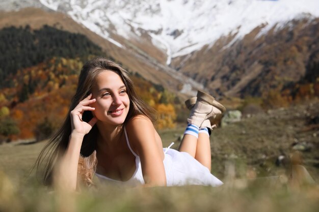 Foto bella giovane donna che si rilassa sulla coperta in montagna