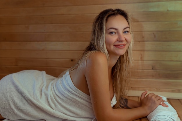 Красивая молодая женщина отдыхает в финской сауне.