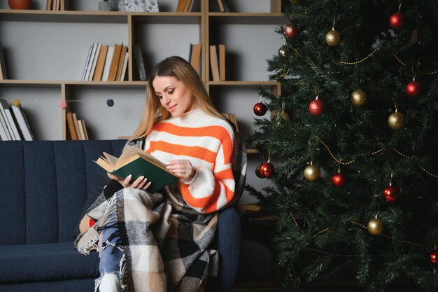 クリスマスの日に家でくつろぐ美しい若い女性