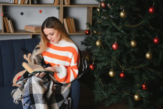 クリスマスの日に家でくつろぐ美しい若い女性