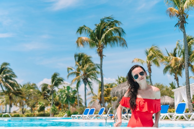 Beautiful young woman relaxing in swimming pool.