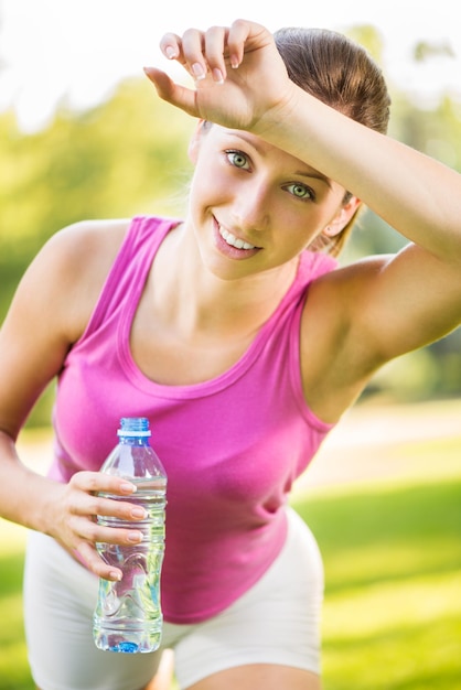 Beautiful young woman resting after exercising in the park.