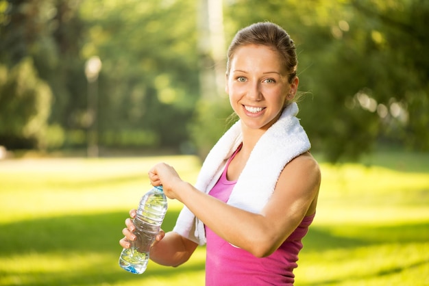 Beautiful young woman resting after exercising in the park.