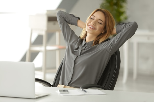 Beautiful young woman resting at workplace in office