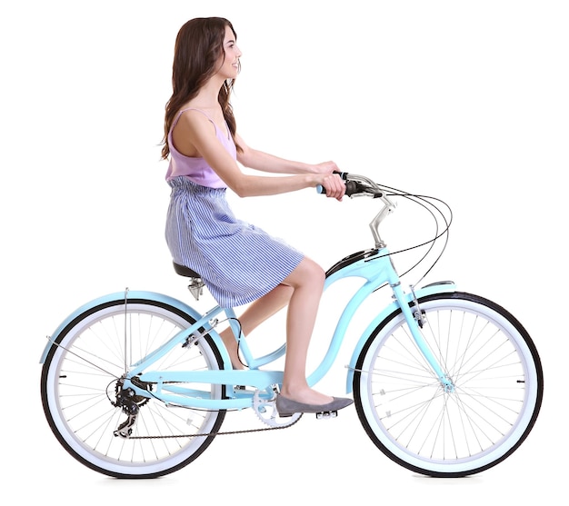 白い背景の上の自転車に乗って美しい若い女性