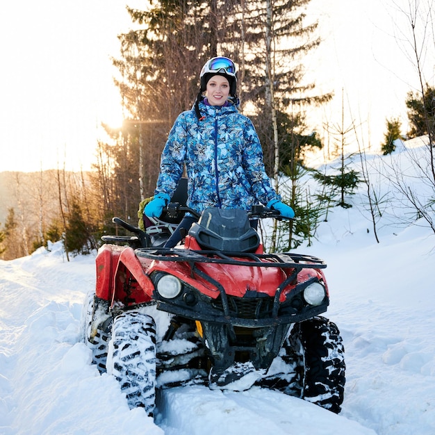 Photo beautiful young woman riding quad bike in mountains