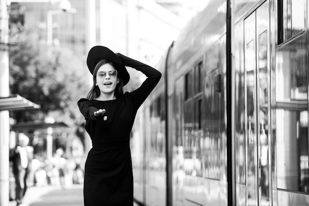 Foto bella giovane donna che corre dietro al filobus nella via della città bella giovane donna di moda