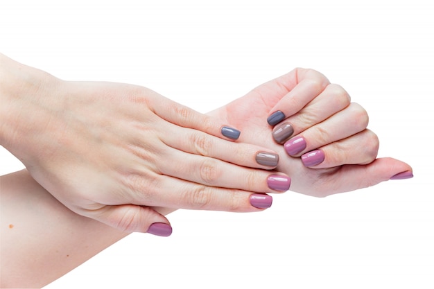 Beautiful young woman's hands isolated on white background. Stylish trendy female manicure with gray, pink and brown nail polish.