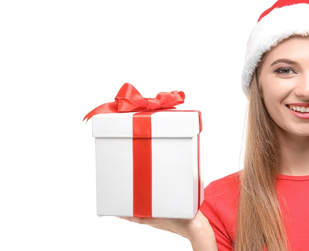 Beautiful young woman in Santa hat holding giftbox, on white background