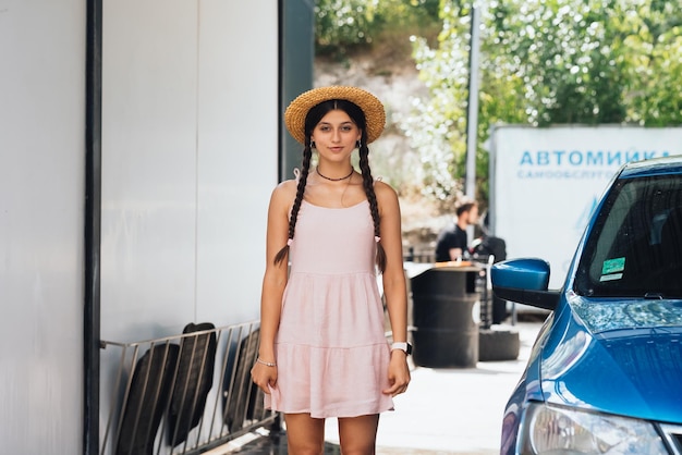 Beautiful young woman in a short dress at car wash