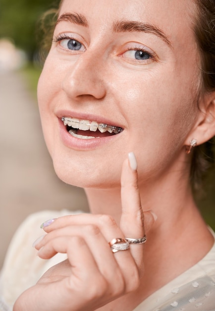 Beautiful young woman showing teeth with braces