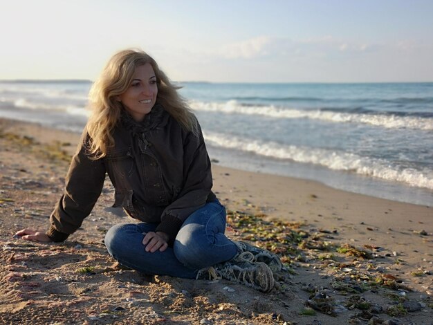 Beautiful young woman sitting on beach